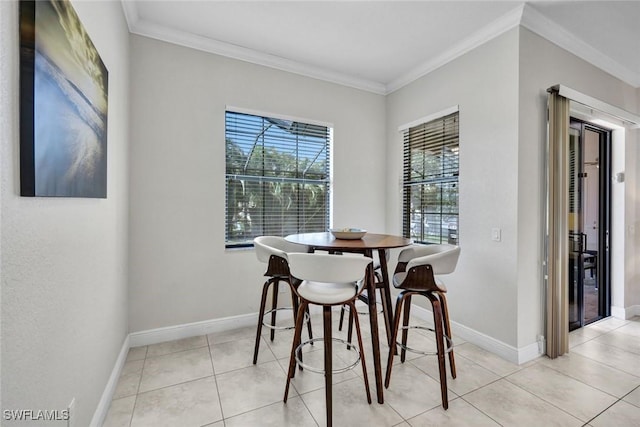 dining area featuring ornamental molding, baseboards, and light tile patterned floors
