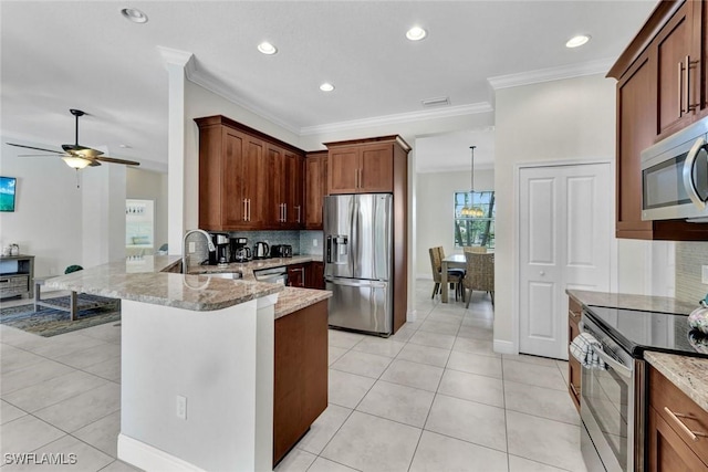 kitchen featuring stainless steel appliances, a sink, tasteful backsplash, light stone counters, and ornamental molding