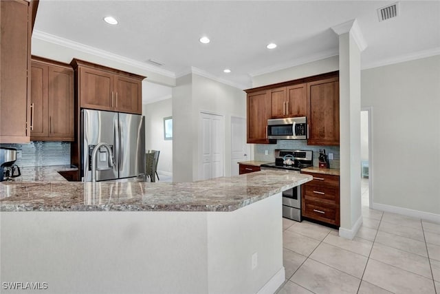 kitchen with stainless steel appliances, light stone countertops, ornamental molding, decorative backsplash, and a peninsula
