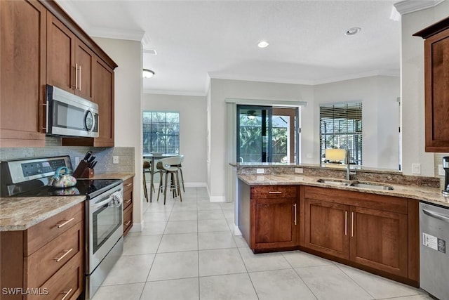 kitchen with appliances with stainless steel finishes, ornamental molding, light stone countertops, decorative backsplash, and a sink