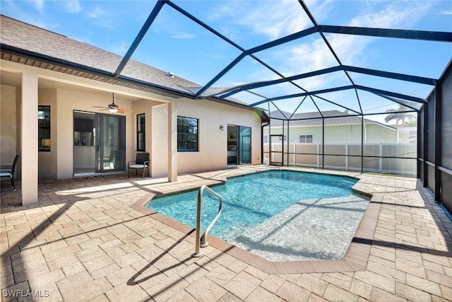 view of swimming pool featuring ceiling fan, a patio area, and glass enclosure