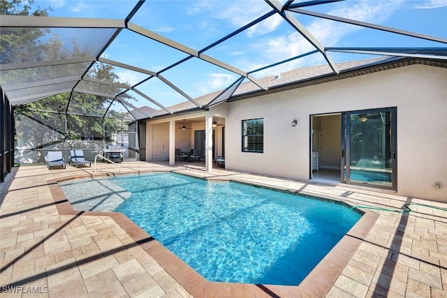 outdoor pool featuring a patio area, ceiling fan, and a lanai