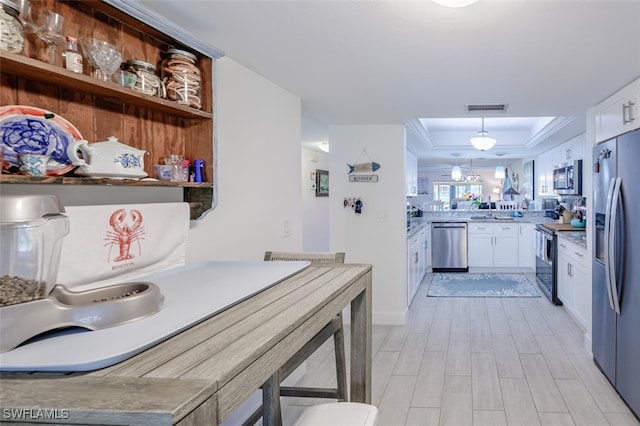 12130 Kelly Greens Blvd Unit 91, Fort Myers, FL 33908 - kitchen with a tray ceiling, white cabinetry, visible vents, and appliances with stainless steel finishes