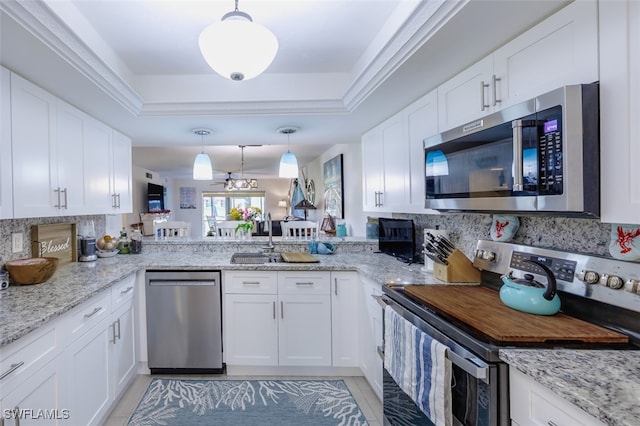 12130 Kelly Greens Blvd Unit 91, Fort Myers, FL 33908 - kitchen with a tray ceiling, tasteful backsplash, white cabinetry, and appliances with stainless steel finishes