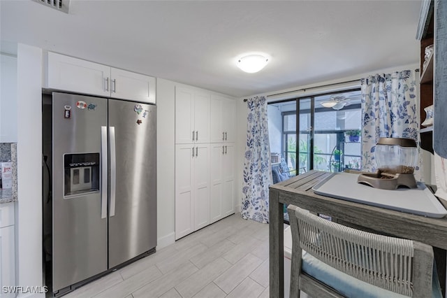 12130 Kelly Greens Blvd Unit 91, Fort Myers, FL 33908 - kitchen with light wood-type flooring, stainless steel fridge, visible vents, and white cabinets