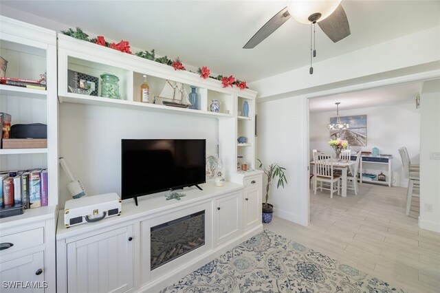 12130 Kelly Greens Blvd Unit 91, Fort Myers, FL 33908 - living room featuring baseboards and ceiling fan with notable chandelier
