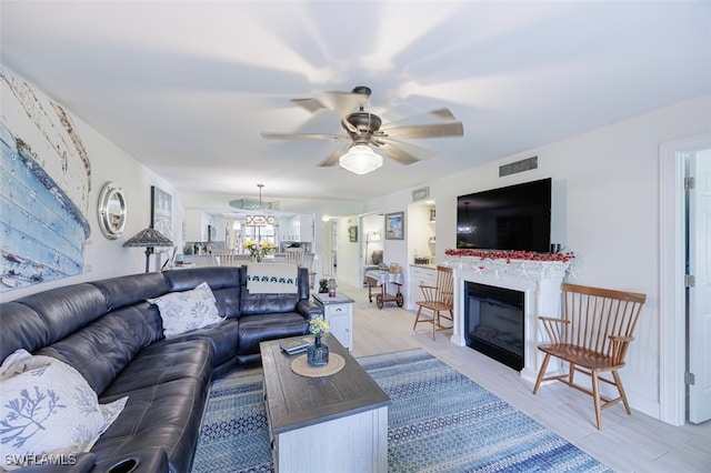 12130 Kelly Greens Blvd Unit 91, Fort Myers, FL 33908 - living area featuring visible vents, a ceiling fan, and a glass covered fireplace