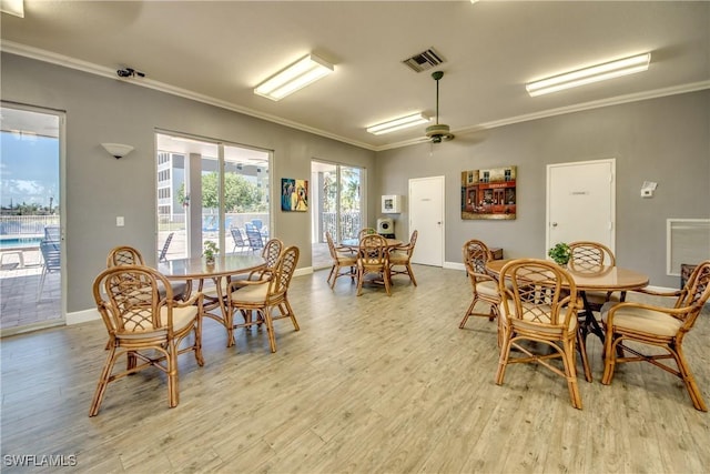 dining space featuring baseboards, ornamental molding, light wood finished floors, and visible vents