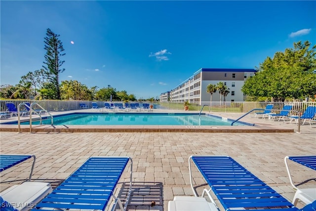 community pool with a patio and fence