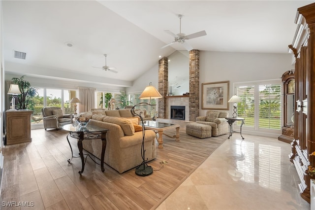living room with ceiling fan, visible vents, high vaulted ceiling, and a fireplace