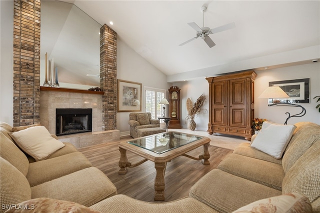 living area featuring wood finished floors, a fireplace, baseboards, ceiling fan, and high vaulted ceiling