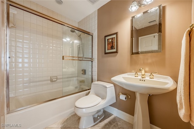 full bath with shower / bath combination with glass door, tile patterned floors, and toilet