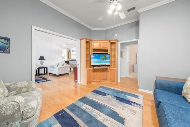 living area featuring ceiling fan, light wood-style floors, and ornamental molding