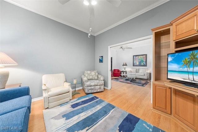 living area with a ceiling fan, crown molding, light wood-style flooring, and baseboards