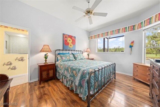 bedroom featuring wood finished floors, baseboards, and a ceiling fan
