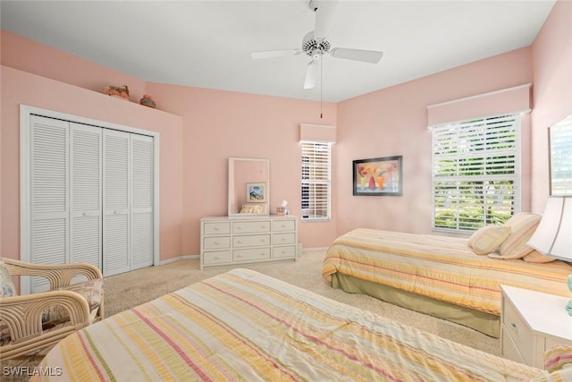 carpeted bedroom with a closet, baseboards, and a ceiling fan