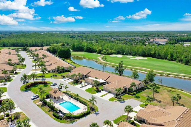 aerial view of residential area featuring a nearby body of water, a local golf course, a pool area, and a forest
