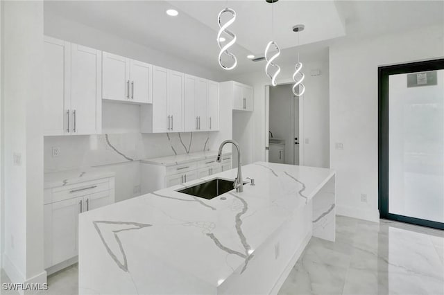 3518 50th St W, Lehigh Acres, FL 33971 - kitchen with a kitchen island with sink, white cabinetry, light stone counters, and a sink