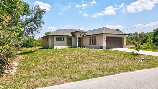 3518 50th St W, Lehigh Acres, FL 33971 - prairie-style house featuring concrete driveway, a garage, a front yard, and stucco siding