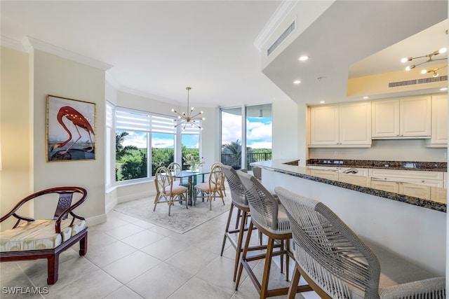 1050 Borghese Ln Unit 206, Naples, FL 34114 - kitchen with a chandelier, ornamental molding, healthy amount of natural light, dark stone countertops, and baseboards