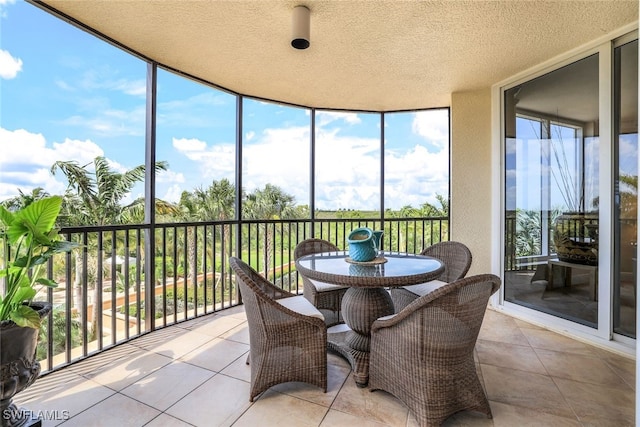 1050 Borghese Ln Unit 206, Naples, FL 34114 - sunroom with expansive windows, a textured ceiling, and tile patterned floors