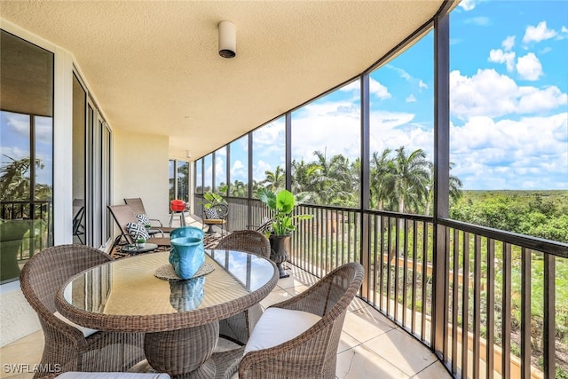 1050 Borghese Ln Unit 206, Naples, FL 34114 - sunroom featuring expansive windows, plenty of natural light, a textured ceiling, outdoor dining area, and tile patterned flooring