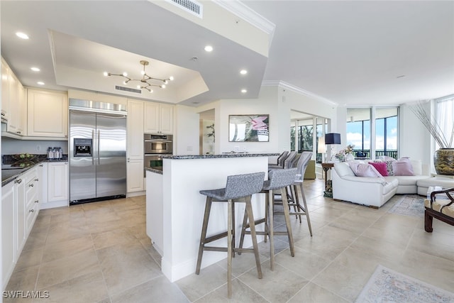 1050 Borghese Ln Unit 206, Naples, FL 34114 - kitchen with appliances with stainless steel finishes, open floor plan, crown molding, a kitchen breakfast bar, and a chandelier