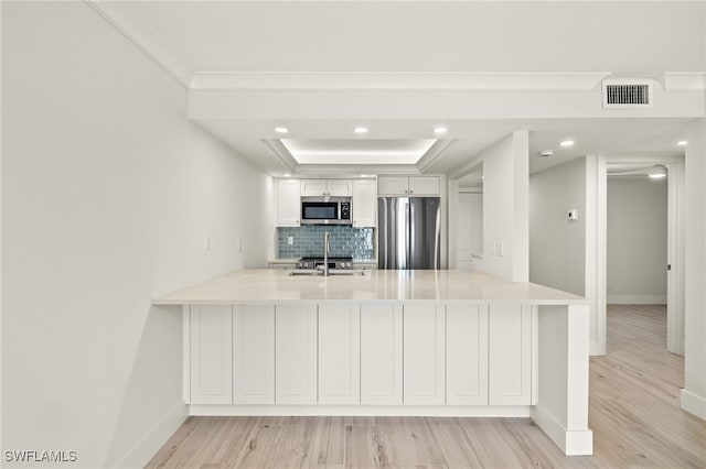 kitchen with baseboards, visible vents, a peninsula, and appliances with stainless steel finishes