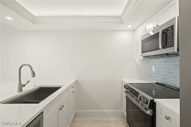 kitchen with stainless steel microwave, a sink, recessed lighting, backsplash, and electric stove