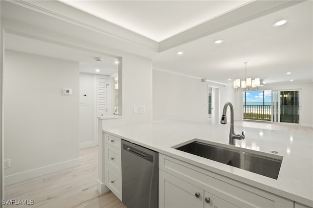 kitchen featuring a sink, light wood finished floors, a chandelier, white cabinets, and stainless steel dishwasher
