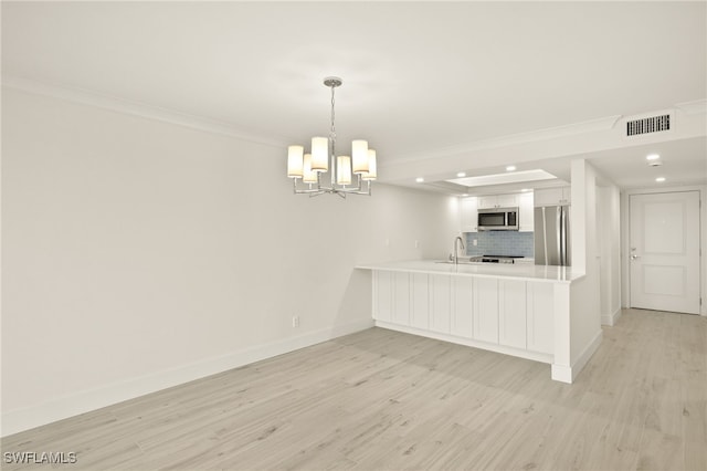 kitchen featuring a peninsula, white cabinetry, stainless steel appliances, and light wood finished floors