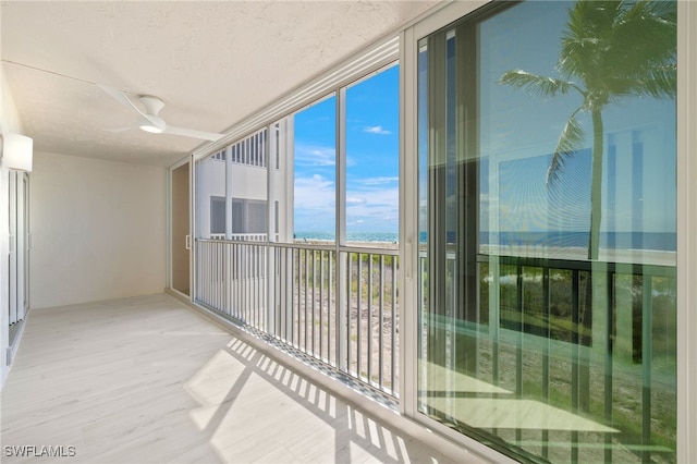 balcony with a water view and ceiling fan