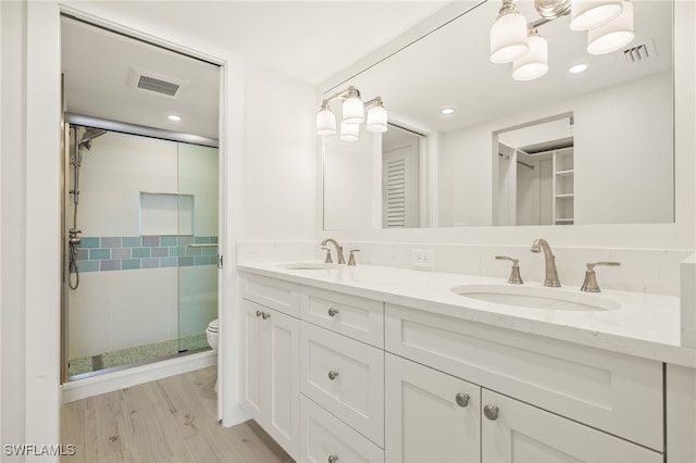 bathroom featuring a sink, a stall shower, and visible vents