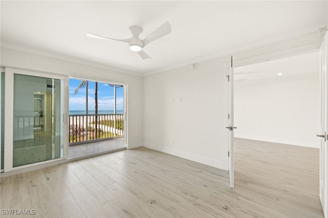 unfurnished room with light wood-style floors, a water view, baseboards, and ceiling fan