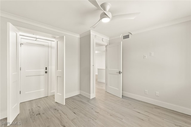 unfurnished bedroom featuring crown molding, light wood-type flooring, visible vents, and baseboards