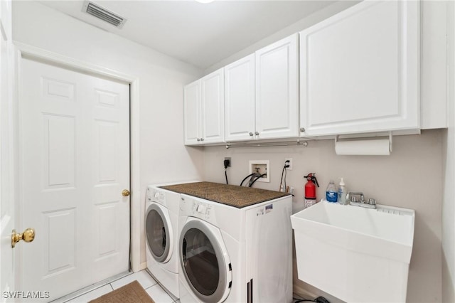 914 SW 3rd Ave, Cape Coral, FL 33991 - washroom with cabinet space, separate washer and dryer, and light tile patterned flooring