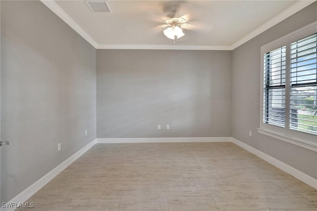 empty room with crown molding, ceiling fan, visible vents, and baseboards