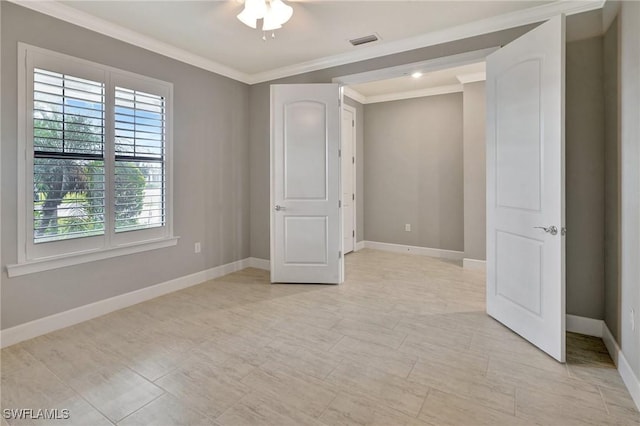 unfurnished bedroom featuring visible vents, baseboards, crown molding, and multiple windows