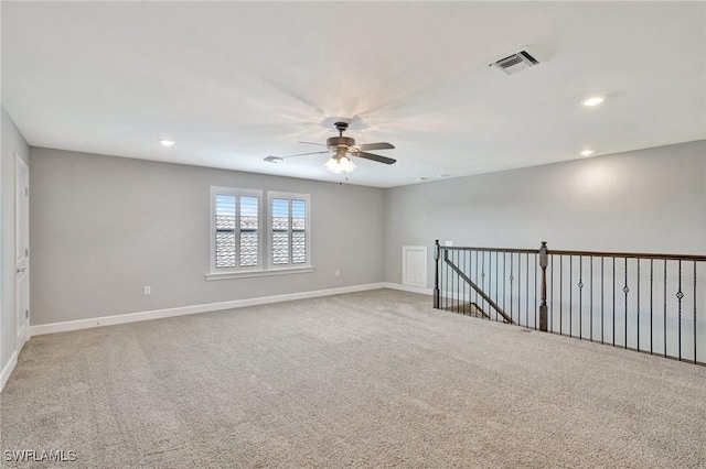 carpeted spare room featuring recessed lighting, ceiling fan, visible vents, and baseboards