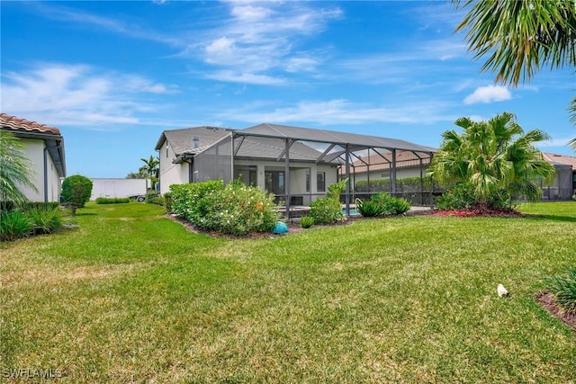 back of house featuring a lawn and a lanai