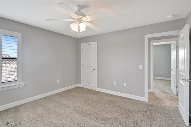 unfurnished bedroom with carpet floors, a ceiling fan, and baseboards