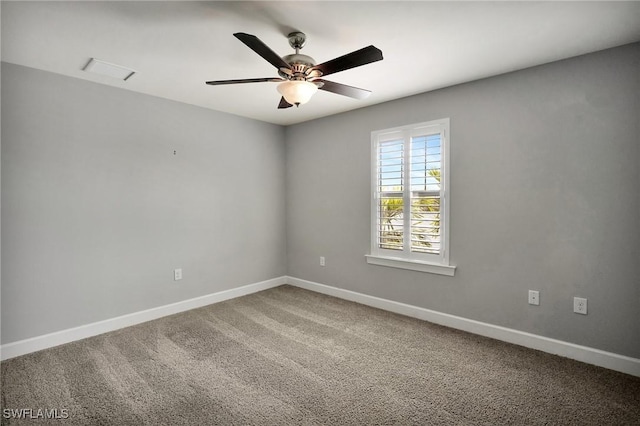 carpeted empty room with baseboards, ceiling fan, and visible vents