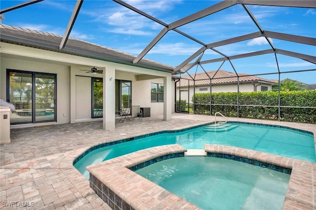 view of swimming pool with a ceiling fan, a lanai, a pool with connected hot tub, and a patio area