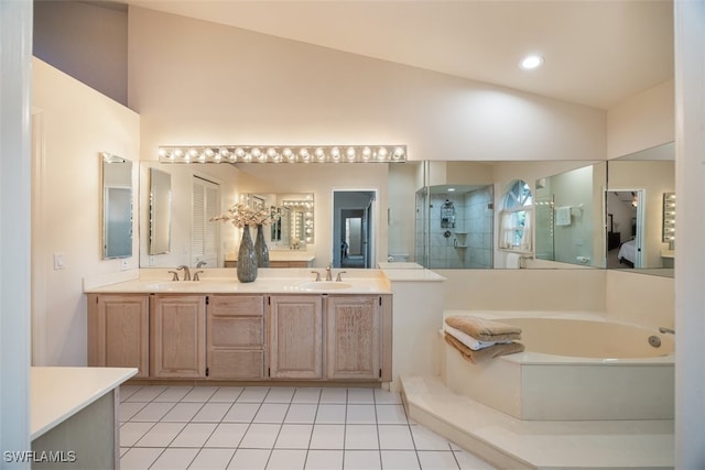 full bathroom with tile patterned flooring, tiled shower, lofted ceiling, and a sink