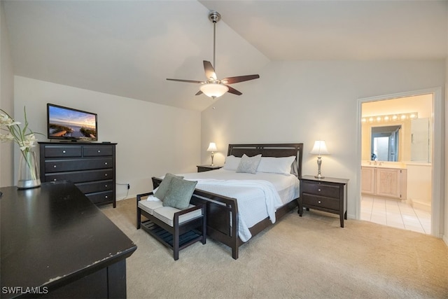 bedroom featuring lofted ceiling, light carpet, connected bathroom, and ceiling fan