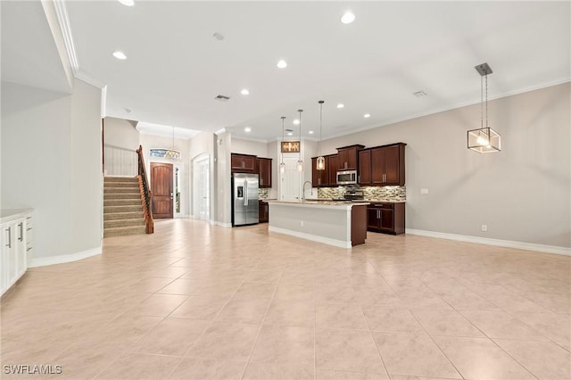 kitchen featuring light countertops, appliances with stainless steel finishes, ornamental molding, and open floor plan