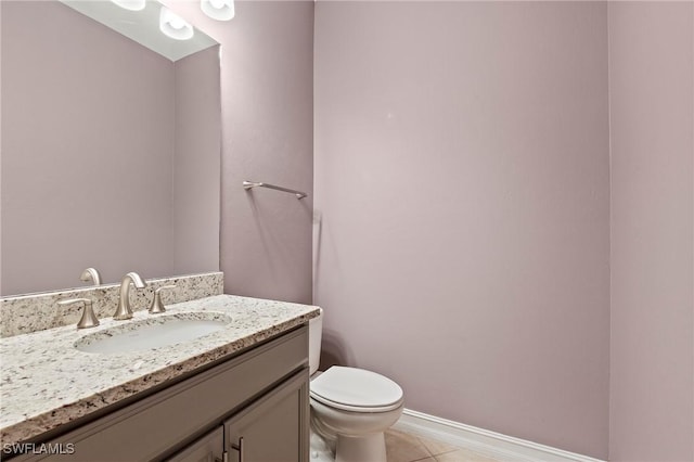 bathroom featuring vanity, tile patterned flooring, baseboards, and toilet