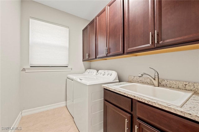 laundry room featuring light tile patterned flooring, baseboards, separate washer and dryer, a sink, and cabinet space