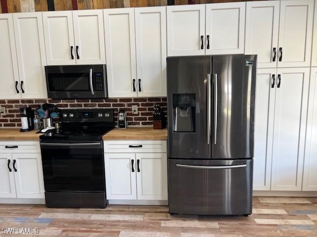7834 15th Pl, Labelle, FL 33935 - kitchen featuring decorative backsplash, wood counters, black electric range oven, and fridge with ice dispenser