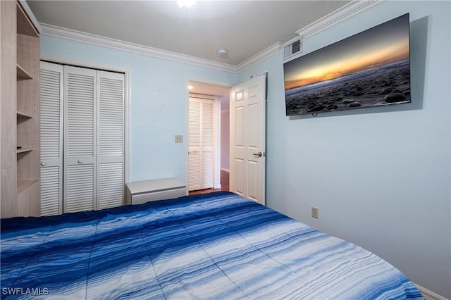 bedroom featuring a closet, visible vents, and crown molding
